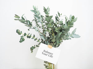 Bouquet of eucalyptus with a small white card attached that says Balance Your Life.