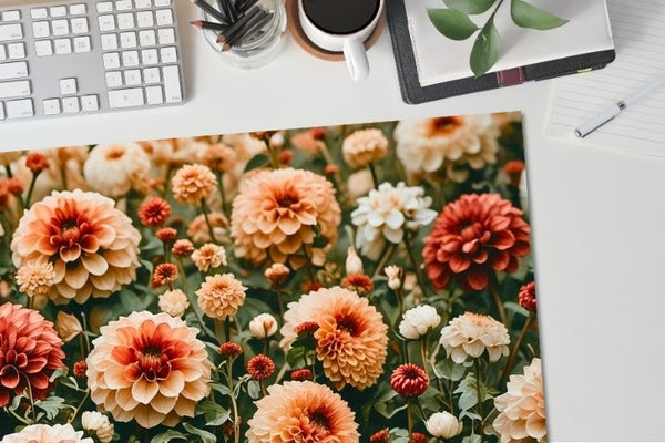 Vibrant Dahlia floral desk mat on a desktop with a keyboard and other office items. 