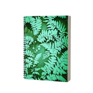 A spiral-bound notebook with a green fern leaf pattern on the cover, shown at a slight angle against a plain white background - Fern Notebook from Spruce and Heron.