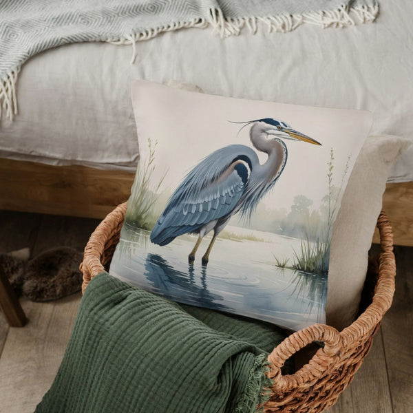 Heron Cushion Cover from Spruce and Heron in a vintage style sitting on top of a basket and blankts. 